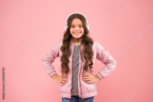 Fun and entertainment. Modern lifestyle. Music gives joy. Happy child listen to music pink background. Little girl wear headphones playing music. New technology for kids © be free