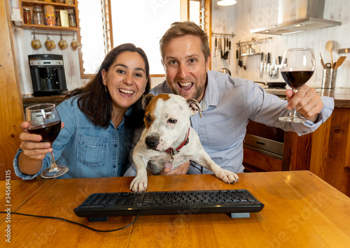 Screen view of Couple with pet dog chatting online celebrating easing of COVID-19 restrictions