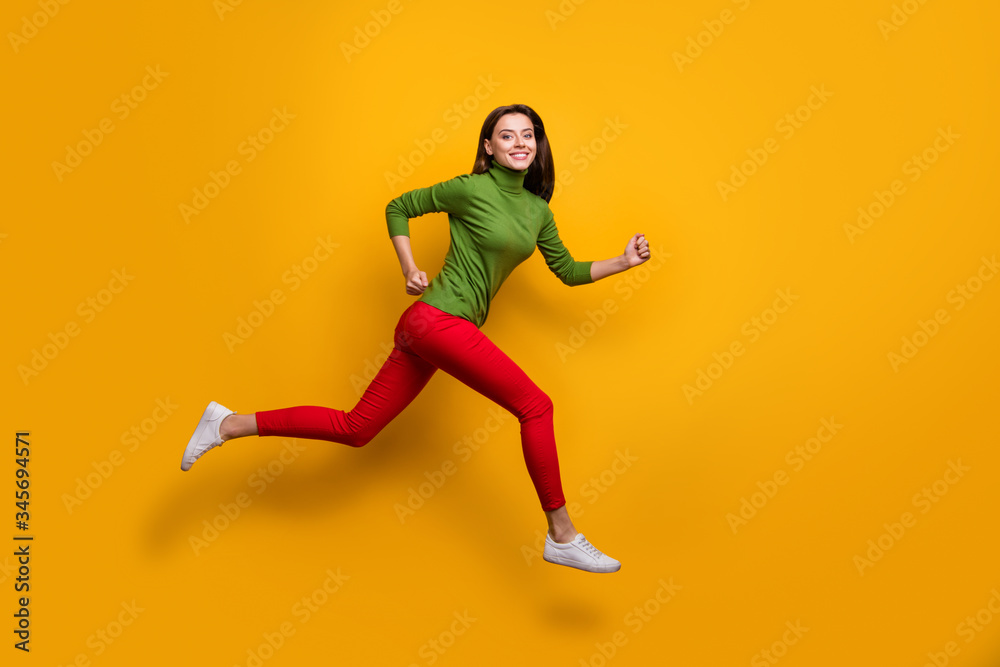 Full size photo of positive cheerful girl jump run fast after black friday sales wear casual style clothes white sneakers isolated over vibrant color background