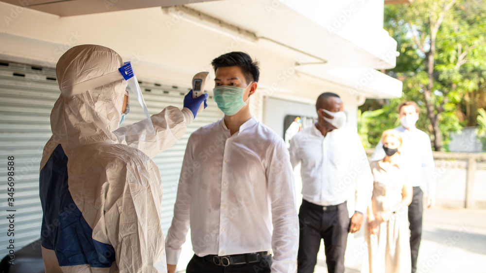 Officer wearing a respirator mask to use infrared forehead thermometer to check fever body temperature for virus symptoms. Respiratory diseases such as flu, covid19, coronavirus. Epidemic outbreak Officer wearing a respirator mask to use infrared forehead thermometer to check fever body temperature for virus symptoms. Respiratory diseases such as flu, covid19, coronavirus. Epidemic outbreak