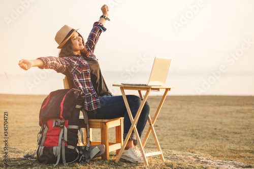Businesswoman working on laptop is outside in early morning, she is young and attractive girl. Work from anywhere lifestyle. Freedom, freelance