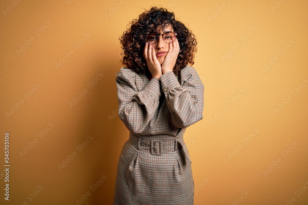 Beautiful arab business woman wearing dress and glasses standing over yellow background Tired hands covering face, depression and sadness, upset and irritated for problem Beautiful arab business woman wearing dress and glasses standing over yellow background Tired hands covering face, depression and sadness, upset and irritated for problem