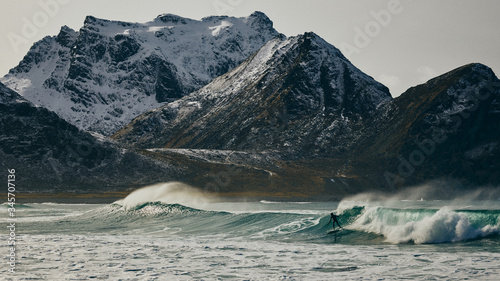 Surfer and snowy mountain backdrop photo