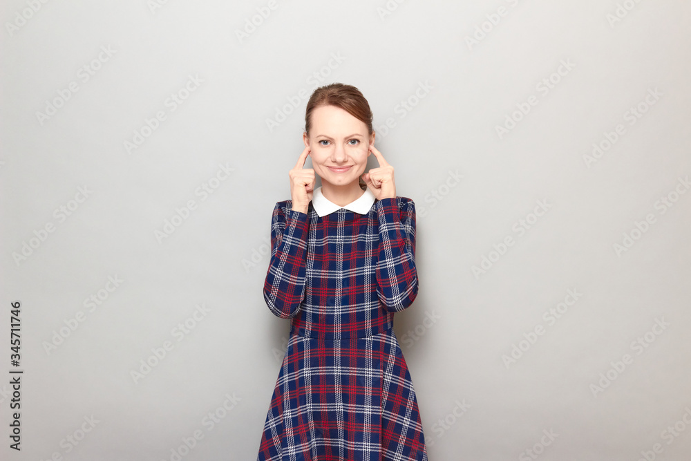 Portrait of happy cheerful young woman plugging her ears with fingers Portrait of happy cheerful young woman plugging her ears with fingers