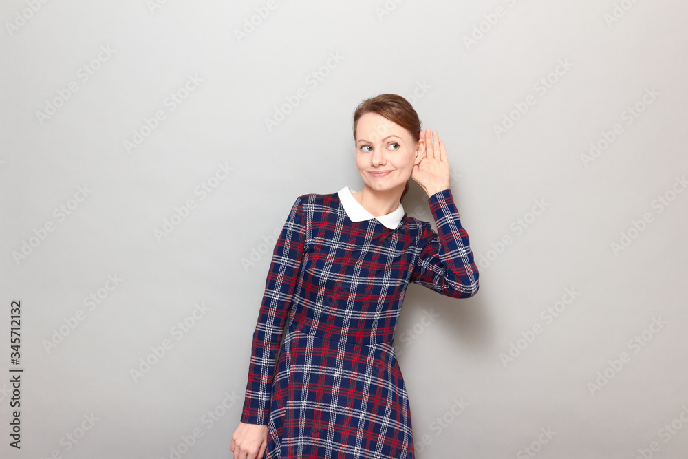 Portrait of young woman placing hand near ear and eavesdropping