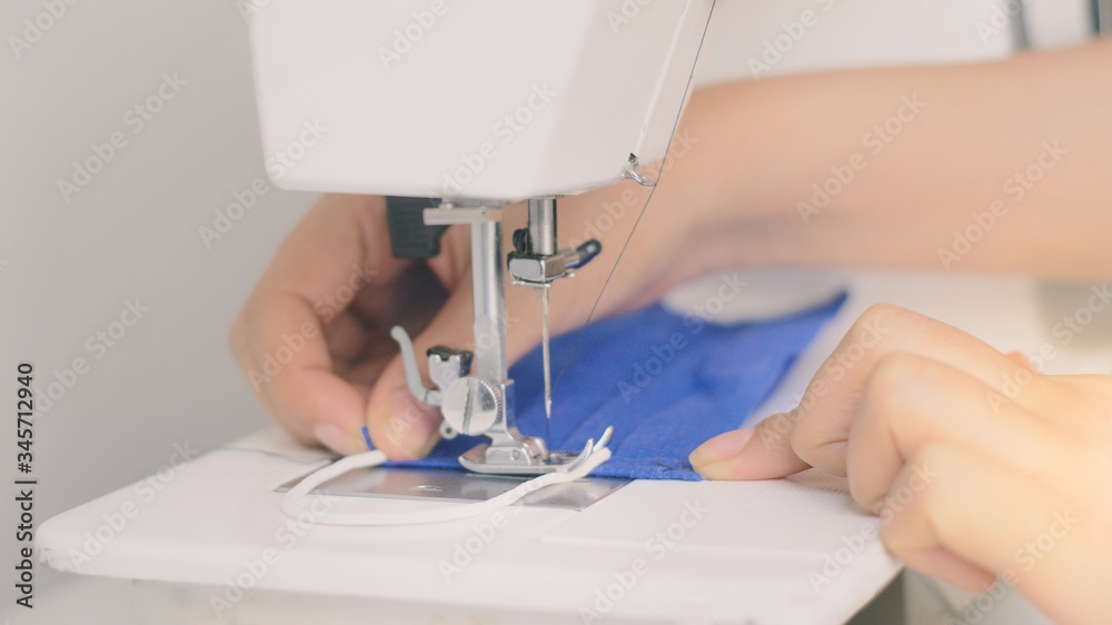 Female hands with sewing machine making mask at home. Pandemic quarantine Stock Photo Adobe Stock