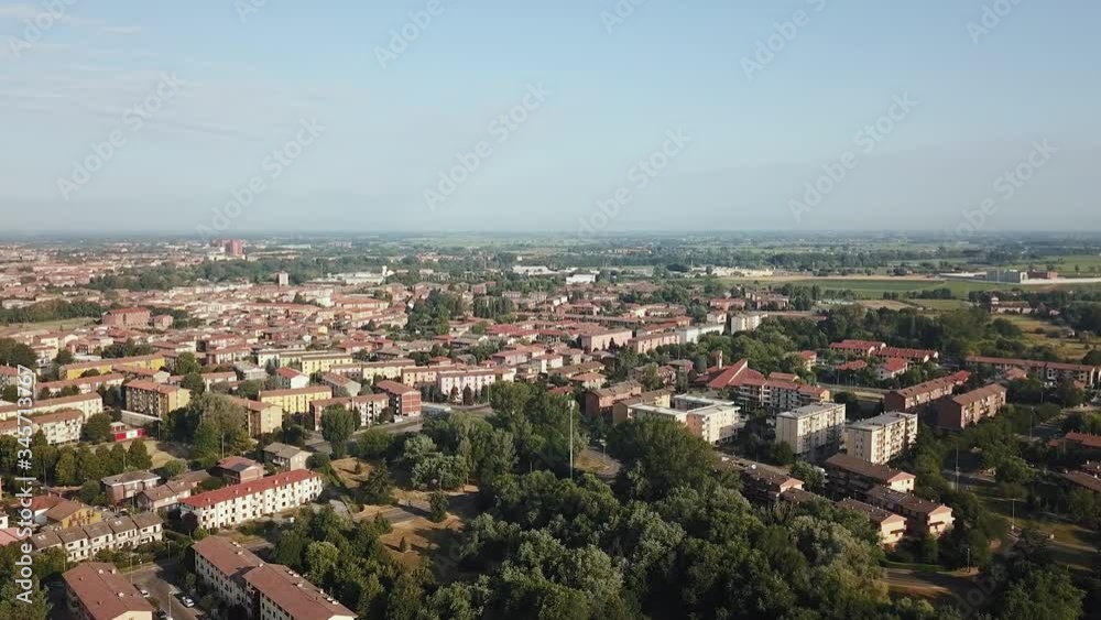Flying over a small city, the horizon shows a lot of low houses under orange tiles and a blue sky. Hot summer time in Italy, aerial view, top view Flying over a small city, the horizon shows a lot of low houses under orange tiles and a blue sky. Hot summer time in Italy, aerial view, top view