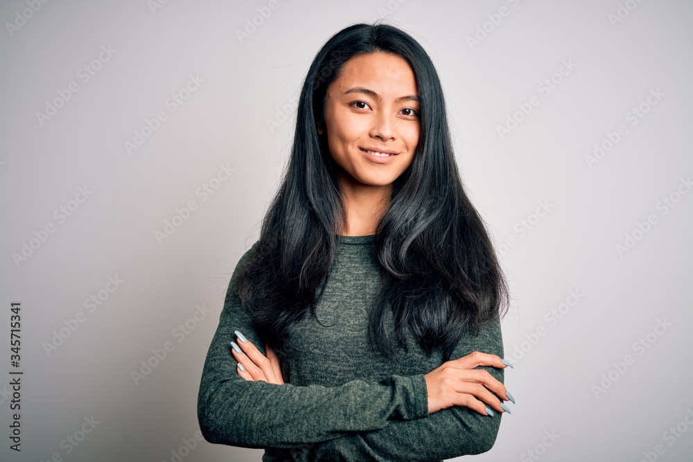 Young beautiful chinese woman wearing casual t-shirt over isolated white background happy face smiling with crossed arms looking at the camera. Positive person. Young beautiful chinese woman wearing casual t-shirt over isolated white background happy face smiling with crossed arms looking at the camera. Positive person.