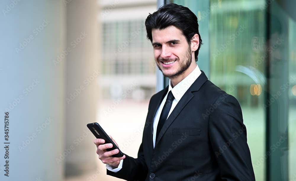 Handsome young manager using a smartphone outdoor Handsome young manager using a smartphone outdoor