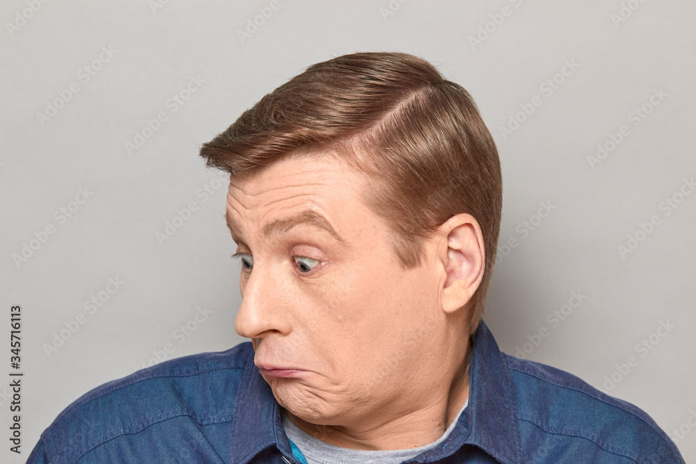 Obraz premium Portrait of blond mature man with silly perplexed expression on face