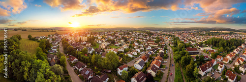 Aerial panorama of a small town at sunrise, with magnificent colorful sky and warm light
