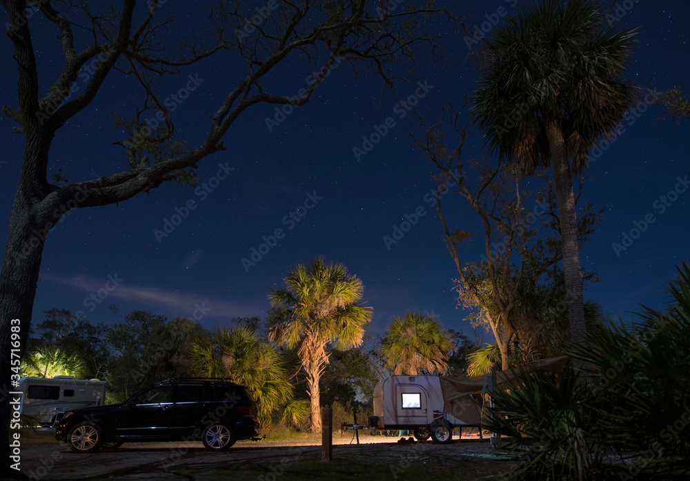 Teardrop camper in campsite at Hunting Island State park, South Carolina at night with stars. Teardrop camper in campsite at Hunting Island State park, South Carolina at night with stars.