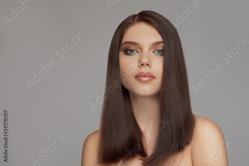 Fashion portrait of a beautiful young brunette with straight hair.