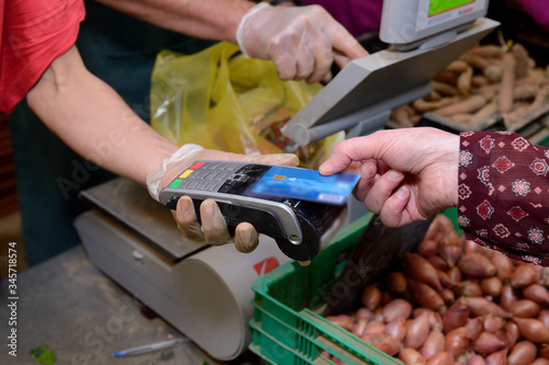 Coronavirus, gestes barrières. Paiment par carte bancaire sans contact sur un marché fermier photo