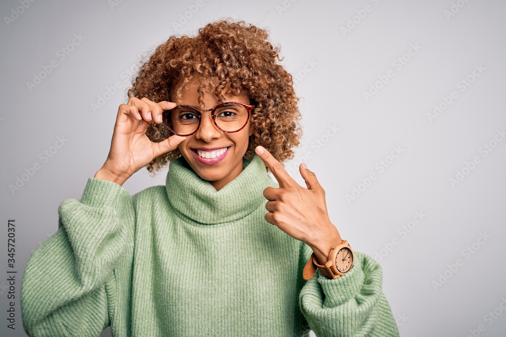African american optical woman with curly hair wearing glasses over isolated white background very happy pointing with hand and finger African american optical woman with curly hair wearing glasses over isolated white background very happy pointing with hand and finger