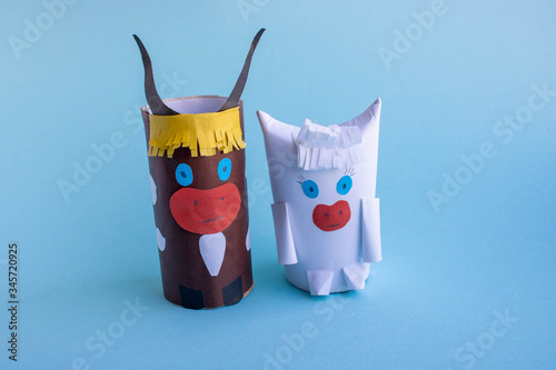 Two funny bulls made of paper and toilet roll on a blue background.New year's fantasy. photo