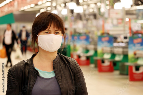 Woman in medical mask in a mall. Concept of shopping during quarantine at covid-19 pandemic