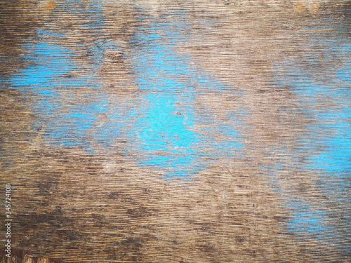 The texture of wooden boards with patches of blue paint.