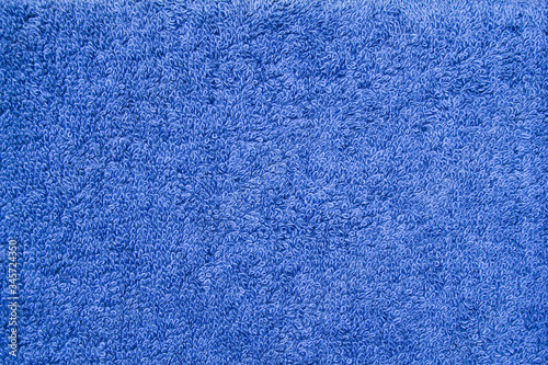 Closeup blue bath terry towel. Blue textile fabric texture background