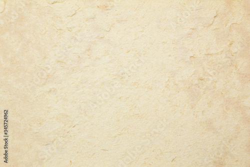 Brown ragged cardboard paper with peeling layers and grungy surface texture background.