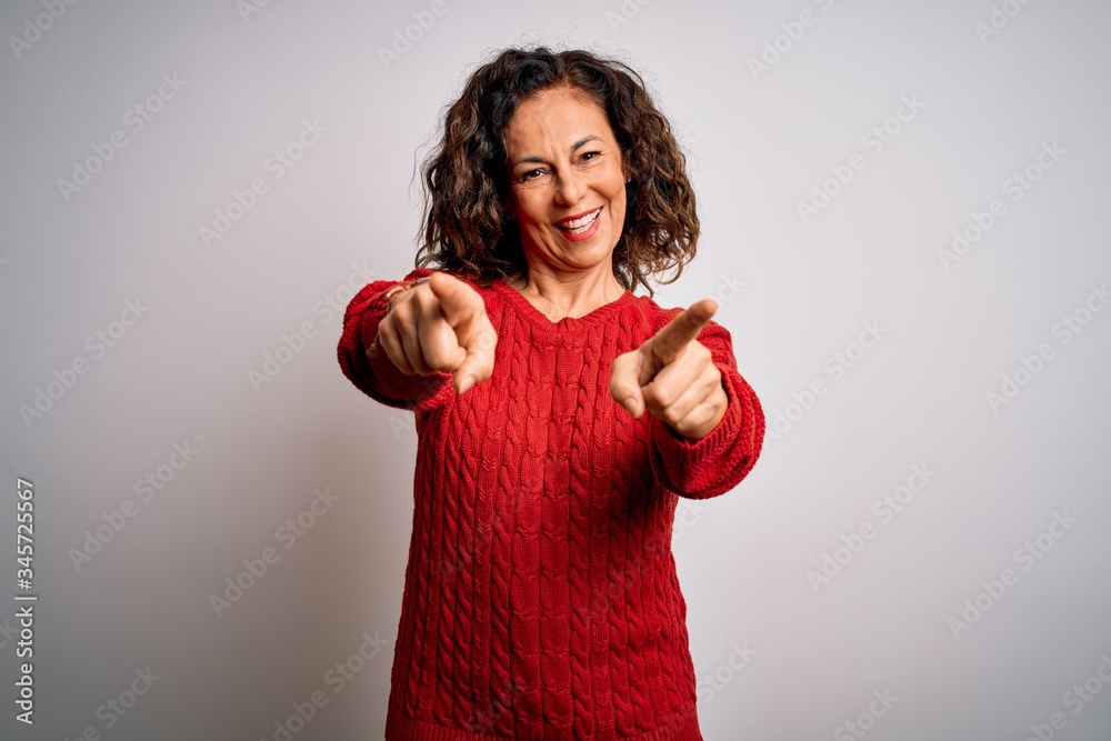 Middle age brunette woman wearing casual sweater standing over isolated white background pointing to you and the camera with fingers, smiling positive and cheerful Middle age brunette woman wearing casual sweater standing over isolated white background pointing to you and the camera with fingers, smiling positive and cheerful
