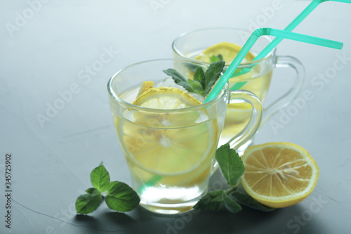 two glass cups of lemonade on a gray background, toned blue color, place for your text
