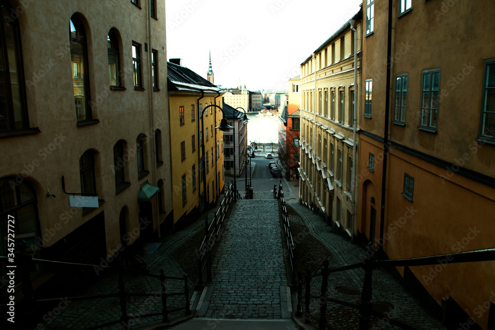 Picturesque cobblestone pathway for pedestrians down the stairs towards the water between old buildings in Stockholm, Sweden