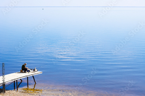 a lone fisherman on the Bank of a large river of the sea