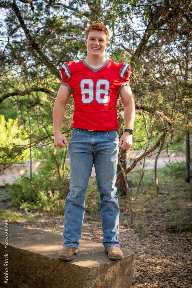 Fototapeta premium Young, attractive boy with red hair taking graduation pictures