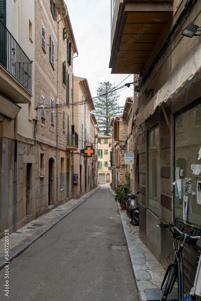 kleine Straße in einem Spanischen Ort mit beleuchtetem Apothekenschild