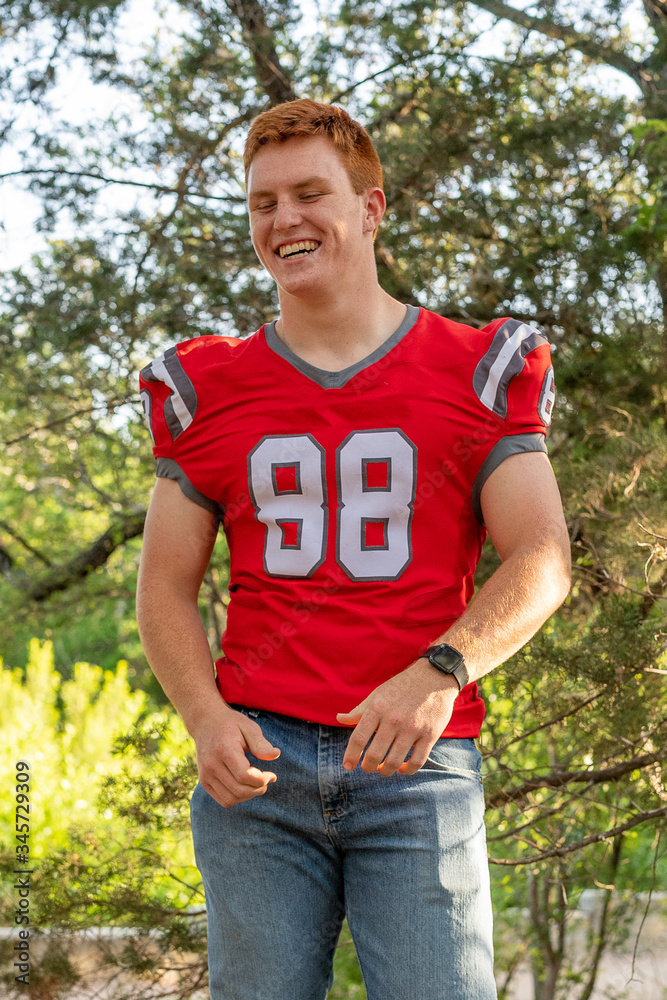Fototapeta premium Young, attractive boy with red hair taking graduation pictures