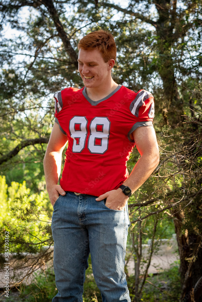 Naklejka premium Young, attractive boy with red hair taking graduation pictures
