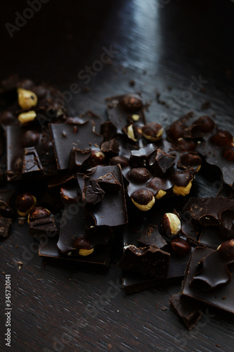 Fototapeta Naklejka Na Ścianę i Meble -  Dark chocolate with nuts on the dark wooden background
