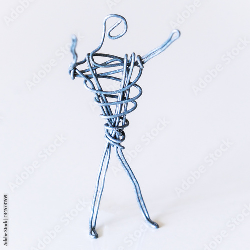 A man of wire is standing, raising his hands up, symbolizing success, joy, dream