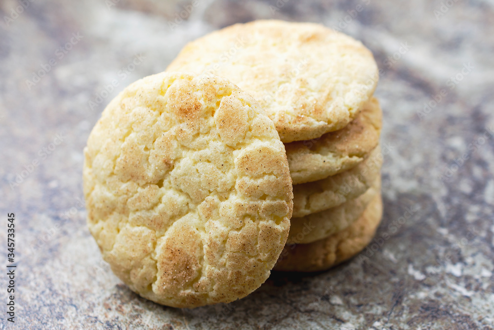 A stack of snickerdoodle cookies on a granite surface. Background blurry. Landscape cropped. Close up on cookie facing camera. A stack of snickerdoodle cookies on a granite surface. Background blurry. Landscape cropped. Close up on cookie facing camera.
