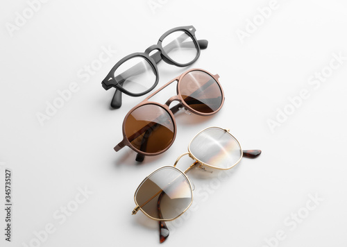 Three pair of modern men sunglasses and eyeglasses on white background isolated with reflection and shadow.