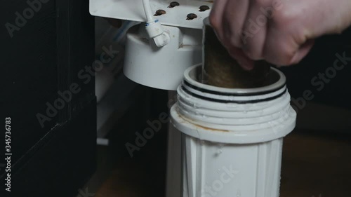 Plumber or Man hand replace cartridges for water filter in home kitchen. Fixed water system cleaning. A man sets a water filter. water filter