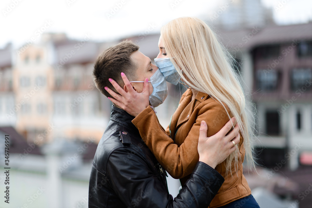Young couple in masks on city street. Young couple in masks on city street.