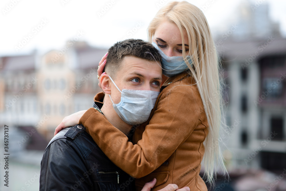 Young couple in masks on city street. Young couple in masks on city street.