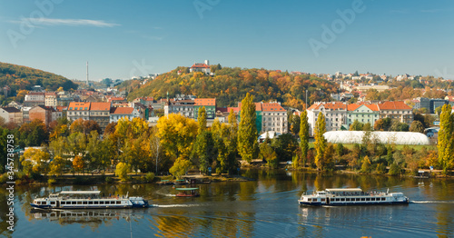 Two pleasure boats on the Vltava river against the background of autumn Prague.