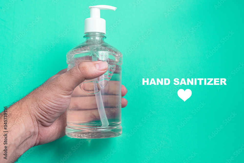 Man hand in container with alcohol gel on the light blue background Man hand in container with alcohol gel on the light blue background