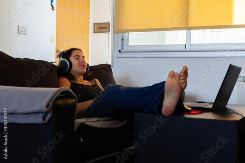 young and beautiful woman listening to music with the computer