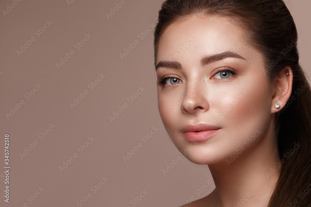 Beautiful young girl with natural nude make-up with cosmetic in hands. Beauty face.