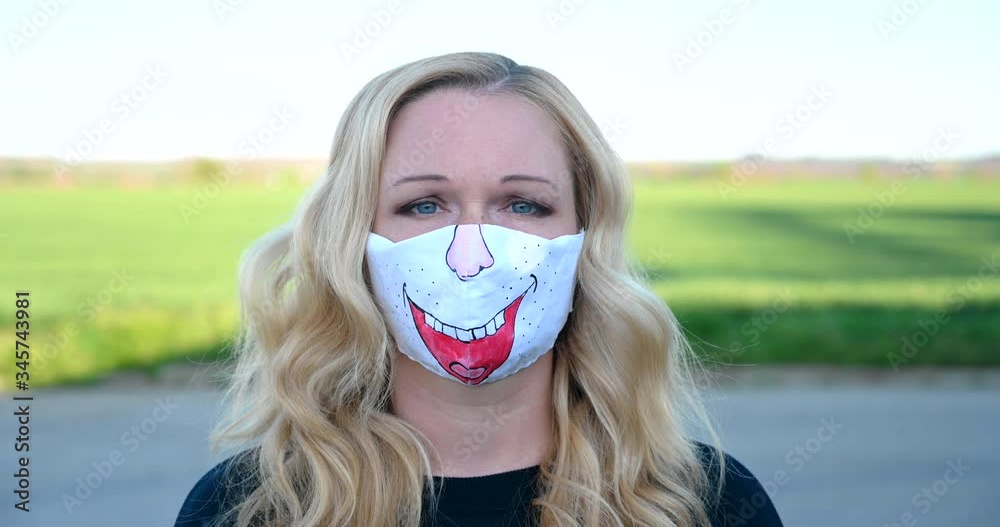 European blond woman wearing original hand made painted face mask during corona virus pandemic European blond woman wearing original hand made painted face mask during corona virus pandemic