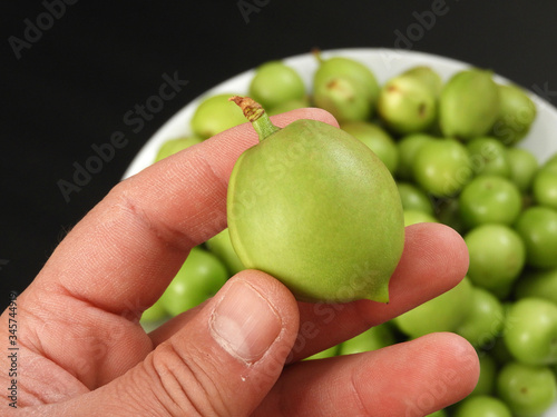 sour nectarine fruit in a person's hand,close-up raw nectarine and sour plum