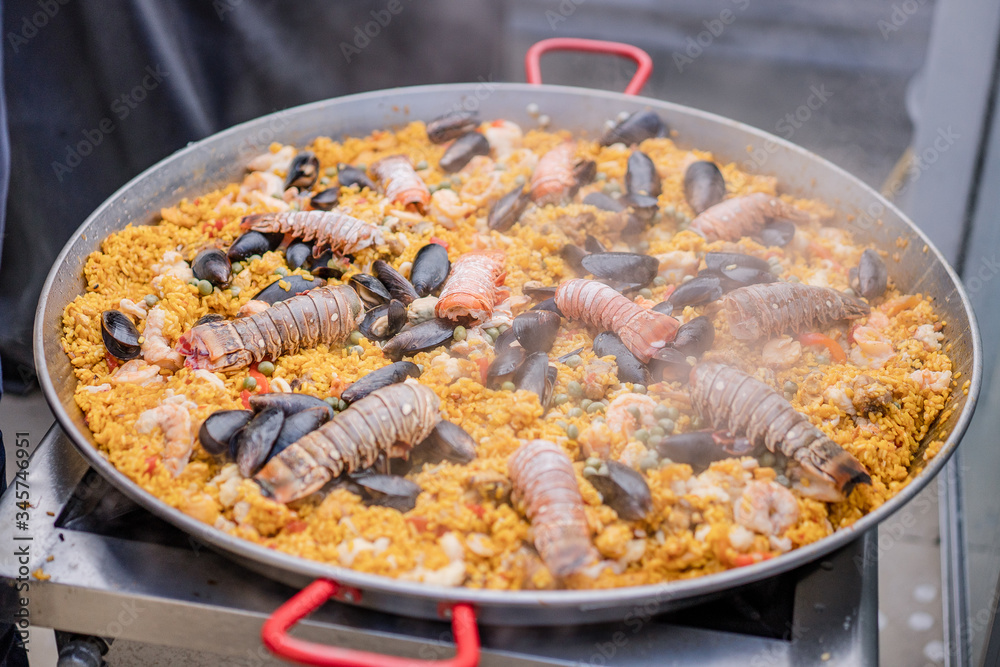 Paella de mariscos, plato con camarones, langosta, langostinos, almejas, arroz y verduras Paella de mariscos, plato con camarones, langosta, langostinos, almejas, arroz y verduras