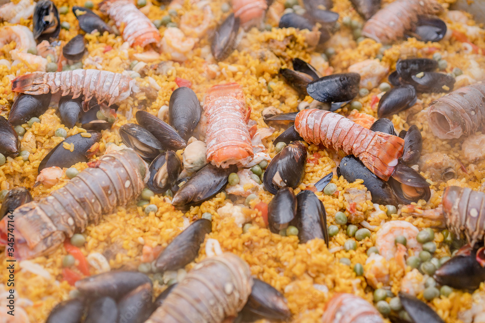 Foto de Paella de mariscos, plato con camarones, langosta, langostinos, almejas, arroz y