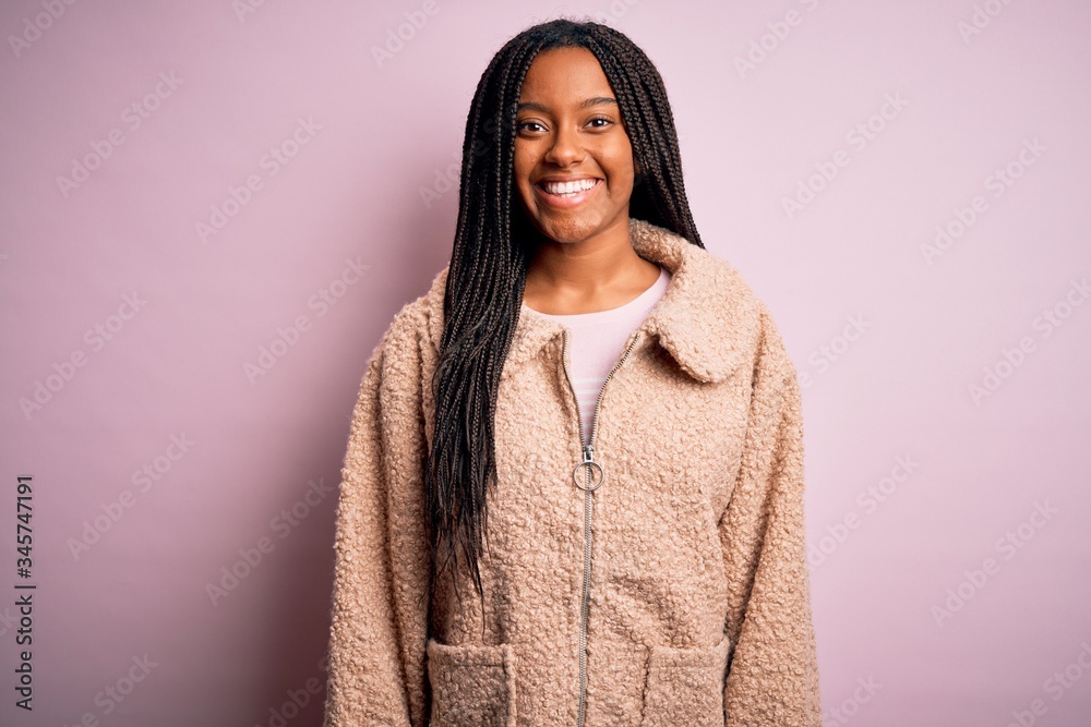 Young african american woman wearing fashion winter coat over pink isolated background with a happy and cool smile on face. Lucky person. Young african american woman wearing fashion winter coat over pink isolated background with a happy and cool smile on face. Lucky person.