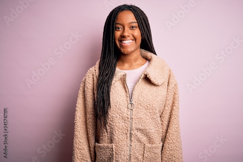 Young african american woman wearing fashion winter coat over pink isolated background with a happy and cool smile on face. Lucky person. © Krakenimages.com