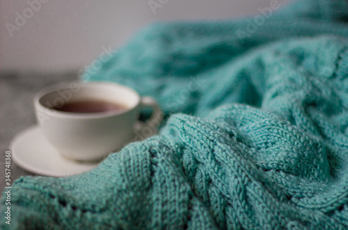 Сup of hot tea and warm hand knitted blanket